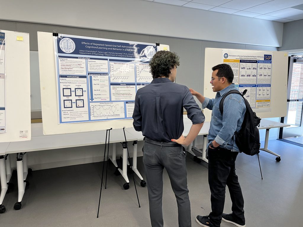 Two psychology students discussing research poster